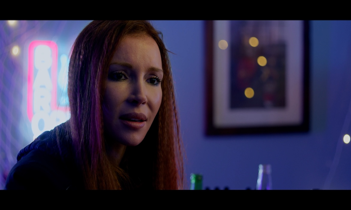 A scene of a girl talking in a bar with a special agent about certain case.