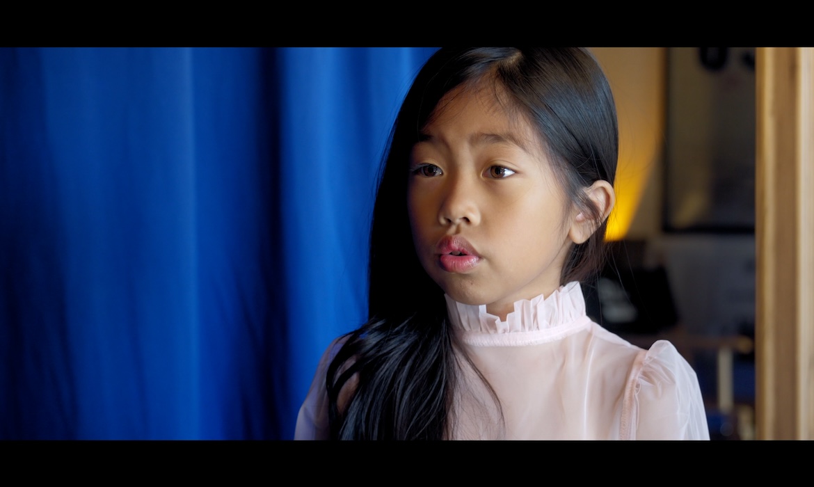 Faith is preparing for audition with her friend in class behind a play.